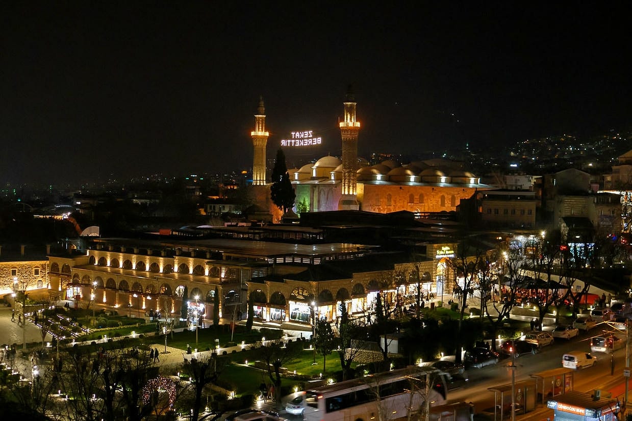A stunning nighttime view of the Bursa Grand Mosque and surrounding area, beautifully illuminated.