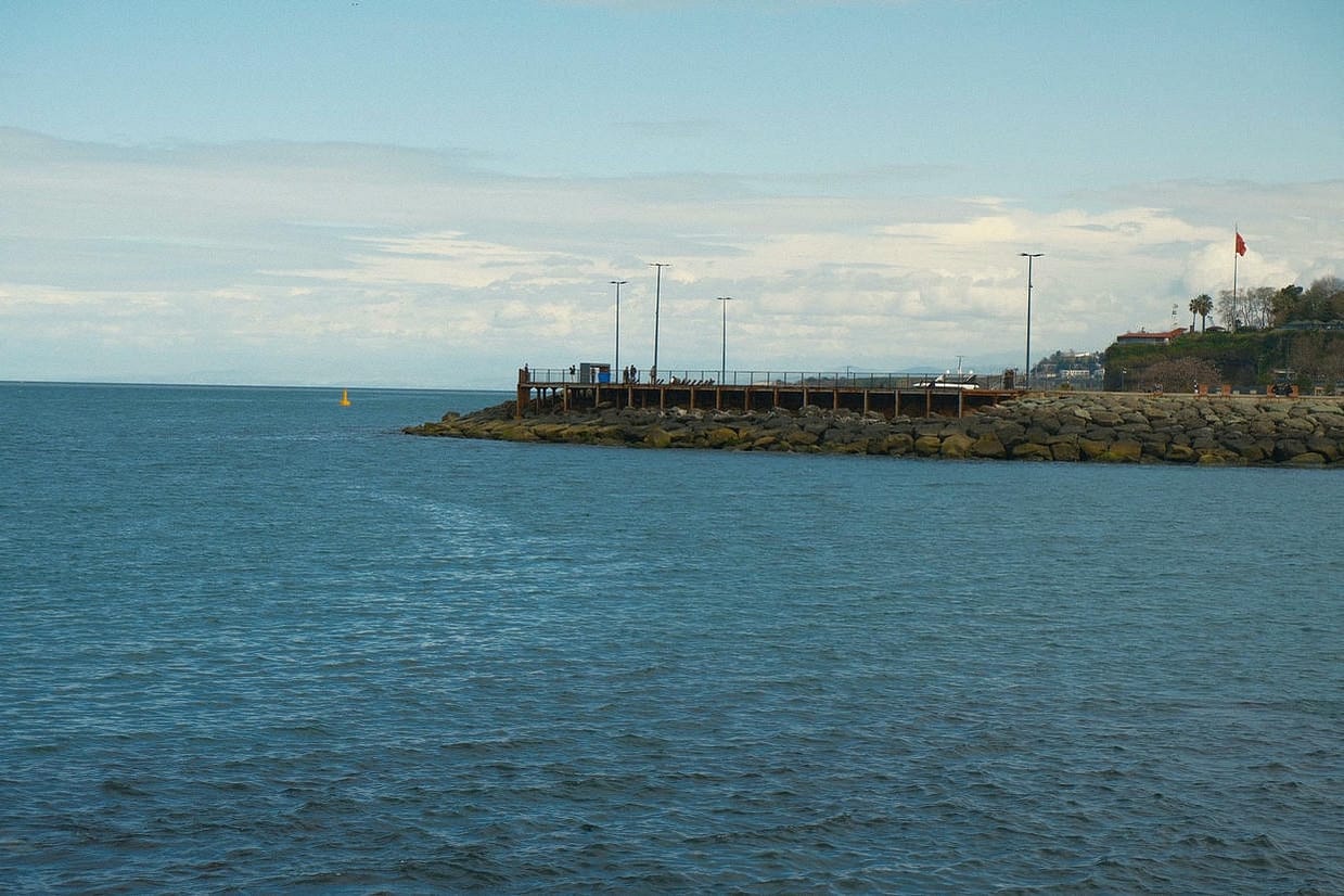 Tranquil coastal view of the Black Sea with a rocky pier in Trabzon, Türkiye.