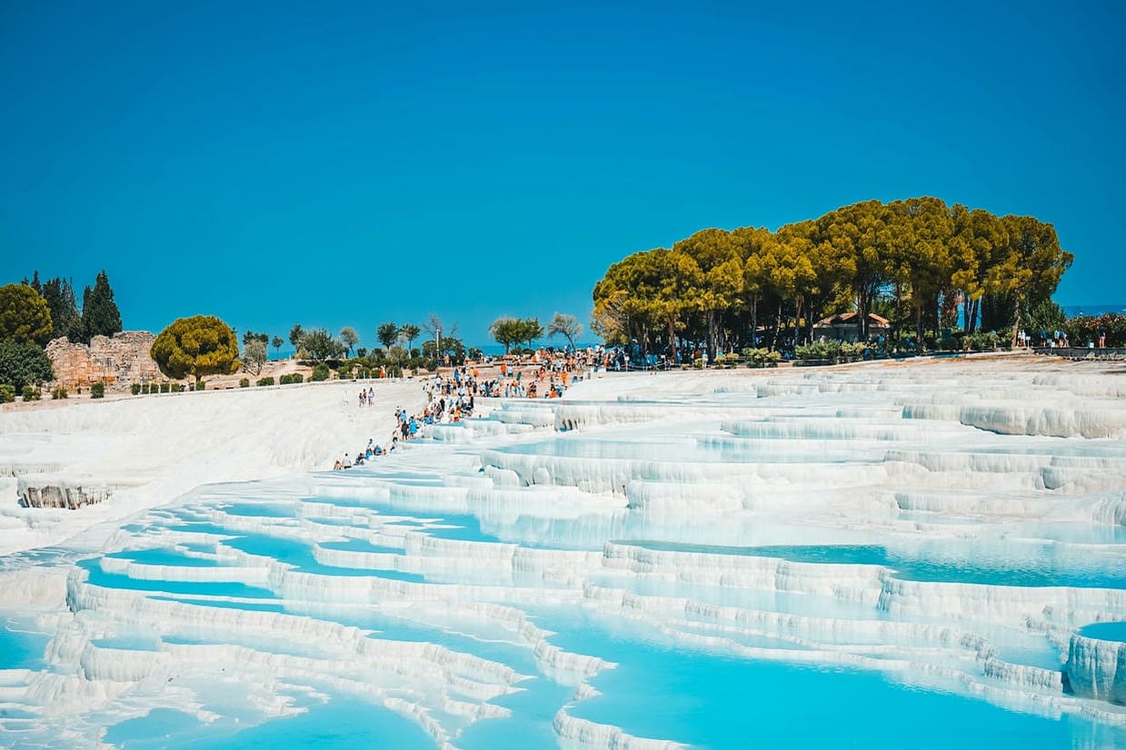 Experience the breathtaking travertine terraces of Pamukkale, Denizli, Türkiye, a natural wonder attracting global visitors.