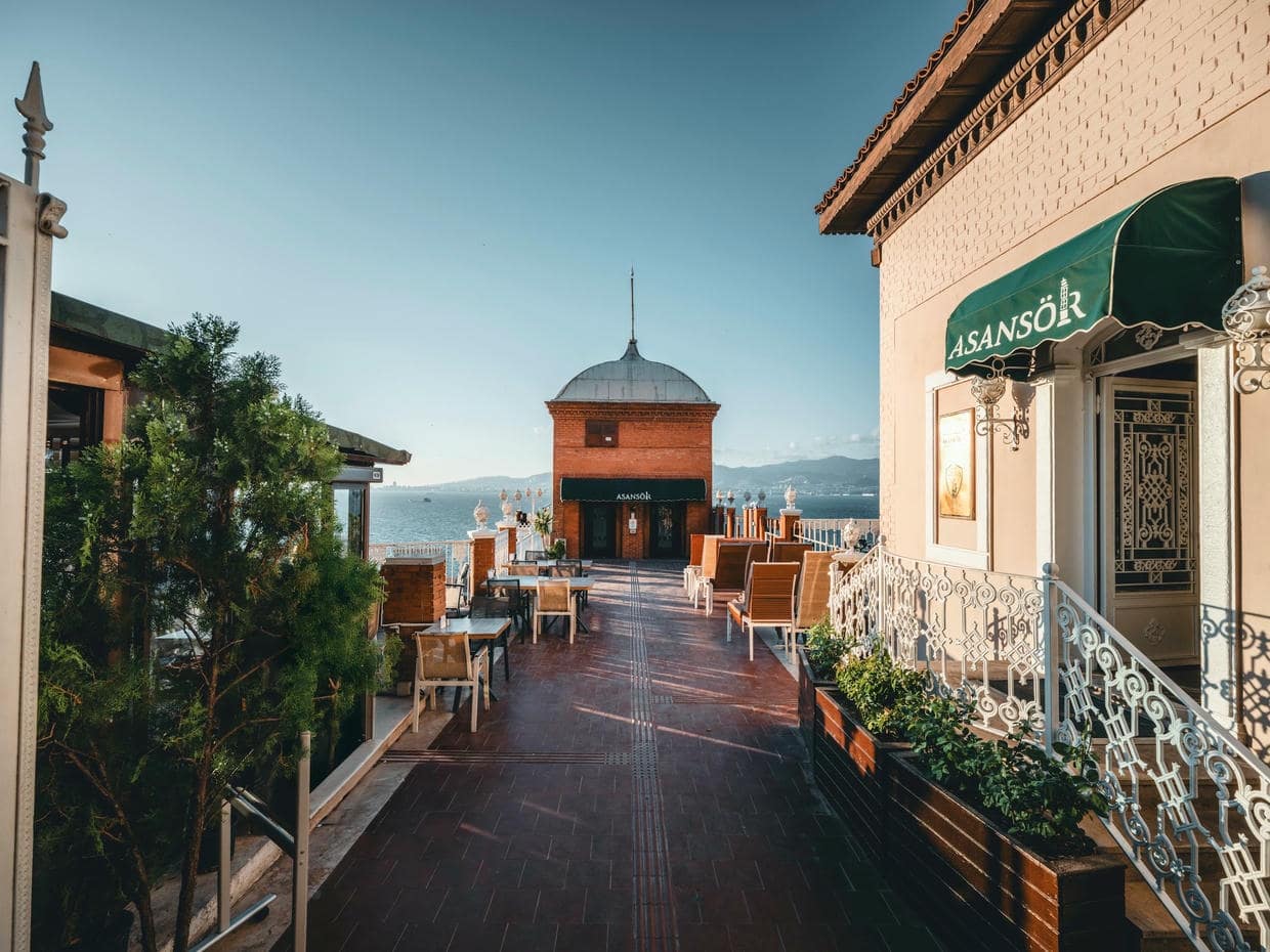Explore the charming walkway and iconic Asansör Tower in İzmir, Türkiye, under clear skies.