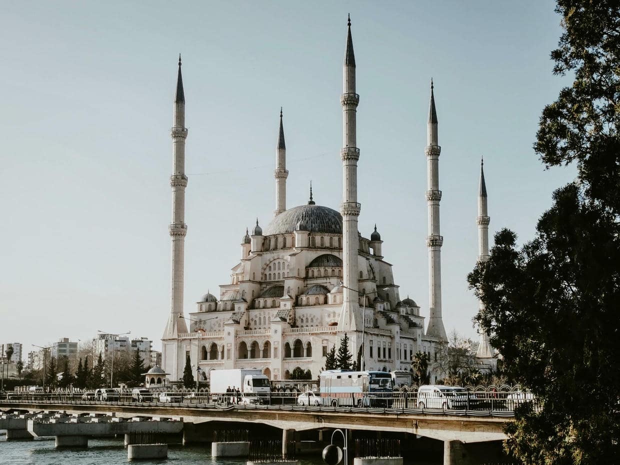 A stunning view of the Sabanci Central Mosque with its minarets and a bridge in Adana, Turkey.