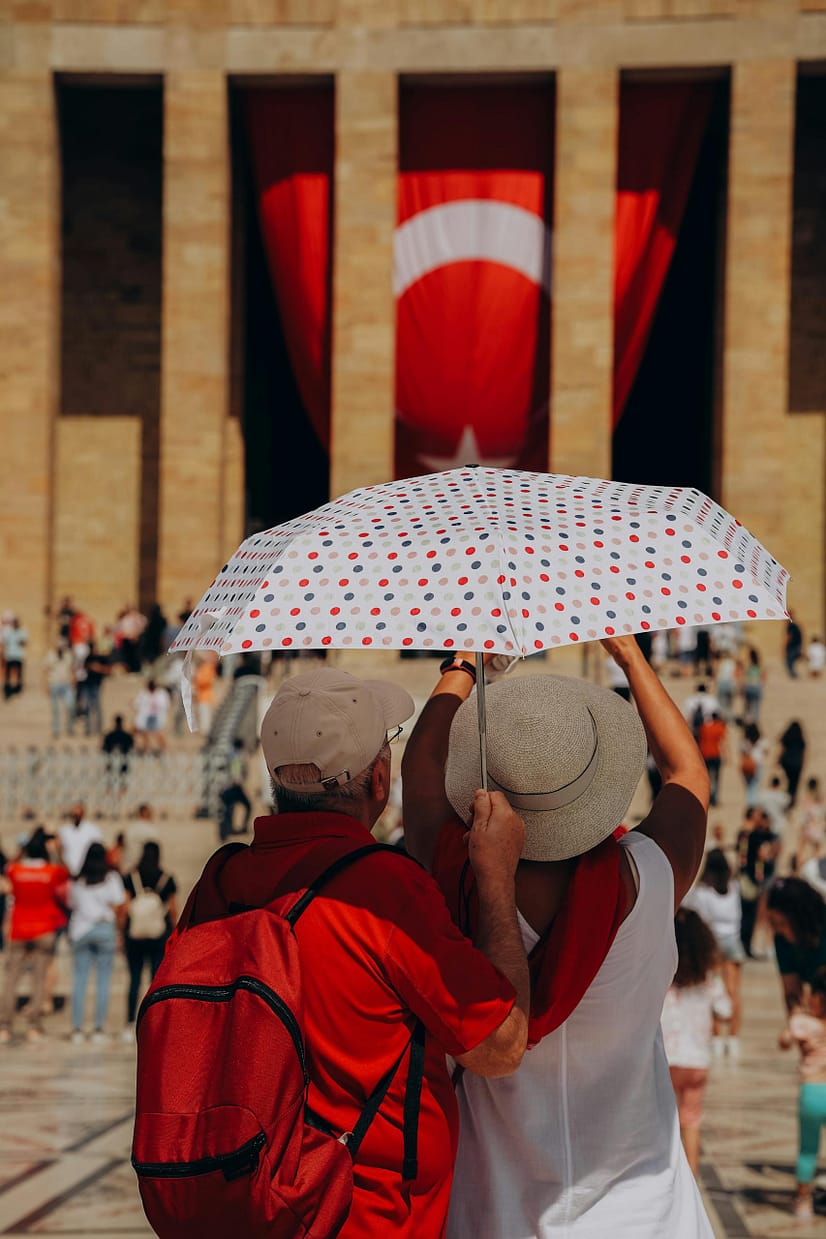A couple under a polka dot umbrella at Anıtkabir, Ankara during a best time to visit Turkey - sunny summer day.